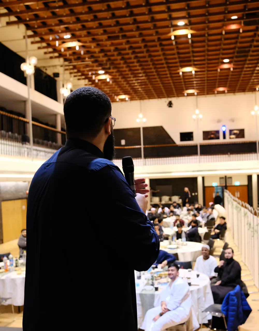 Amro speaking into a microphone.